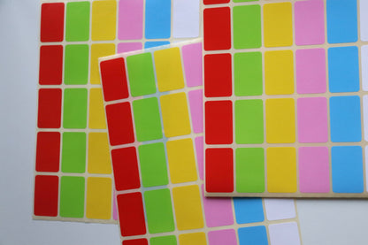 Three sheets of rectangular labels in red, green, yellow, pink, blue, and white.