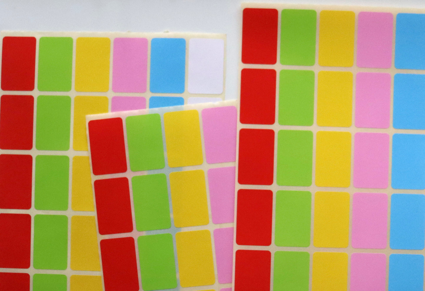 Sheets of colorful rectangular label stickers in red, green, yellow, pink, and blue.